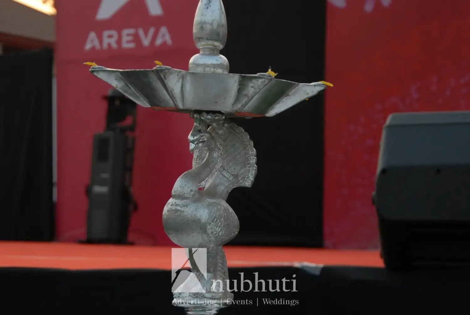 Man and woman speaking on stage at night with blue lighting